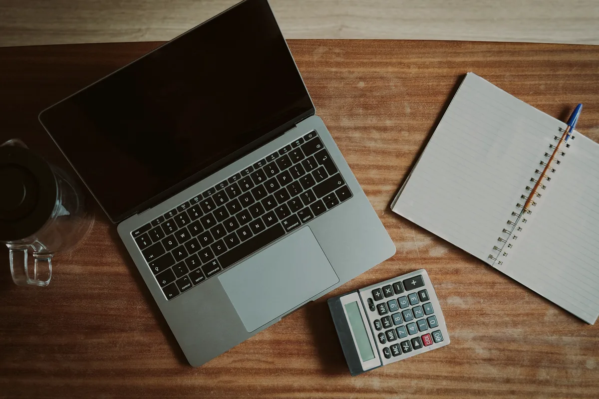 Calculadora e anotações usadas para organizar um orçamento